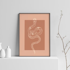 May include: A printable art print featuring a white line drawing of a snake with celestial symbols on a terracotta background.