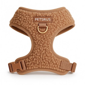 Teddy-style light brown sherpa dog harness by PETsRUS with luxurious gold hardware. Ultra-soft, plush fleece no-pull vest design keeps dogs cozy and secure during walks. Features adjustable straps at neck and chest for a perfect fit. Includes front and back D-ring leash clips for gentle control and training. Easy to wear and remove with quick-release buckle. Ideal for small, medium, and large dogs. A stylish, warm, and functional dog harness for daily comfort and control.