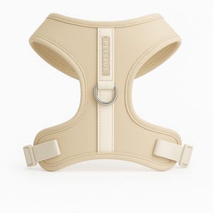 Minimalist ivory cream dog harness from PETsRUS with soft-touch neoprene and silver hardware. Designed for modern aesthetics and pet comfort, this no-pull harness fits small and medium breeds. Dual adjustable straps at chest and neck provide a snug fit. Ideal for daily walks, training, or dressing up your pup. Breathable mesh lining keeps dogs cool. Neutral color complements every fur tone and outfit.