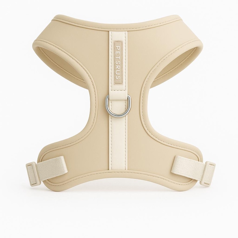 Minimalist ivory cream dog harness from PETsRUS with soft-touch neoprene and silver hardware. Designed for modern aesthetics and pet comfort, this no-pull harness fits small and medium breeds. Dual adjustable straps at chest and neck provide a snug fit. Ideal for daily walks, training, or dressing up your pup. Breathable mesh lining keeps dogs cool. Neutral color complements every fur tone and outfit.
