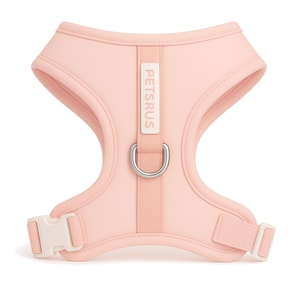 Chic blush pink dog harness with creamy white buckle and silver D-ring by PETsRUS. Soft neoprene body and breathable mesh lining provide comfort for small to medium dogs. Adjustable straps ensure a secure, custom fit. No-pull design with dual leash rings for gentle control. Perfect for stylish pet owners and Instagram-worthy looks. Lightweight, padded, and easy to put on for everyday use and special outings.