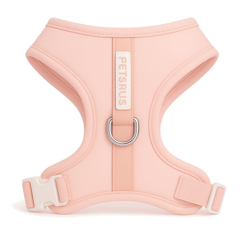 Chic blush pink dog harness with creamy white buckle and silver D-ring by PETsRUS. Soft neoprene body and breathable mesh lining provide comfort for small to medium dogs. Adjustable straps ensure a secure, custom fit. No-pull design with dual leash rings for gentle control. Perfect for stylish pet owners and Instagram-worthy looks. Lightweight, padded, and easy to put on for everyday use and special outings.