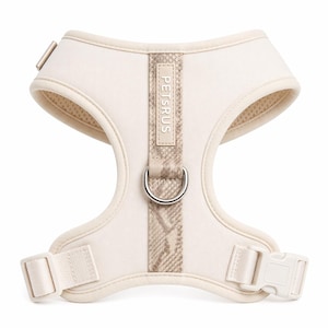 May include: Cream-colored dog harness with a snakeskin-patterned center strap and the text "PETSRUS". The harness features a metal D-ring for leash attachment and adjustable straps with a plastic buckle. The harness is designed for comfort and style.