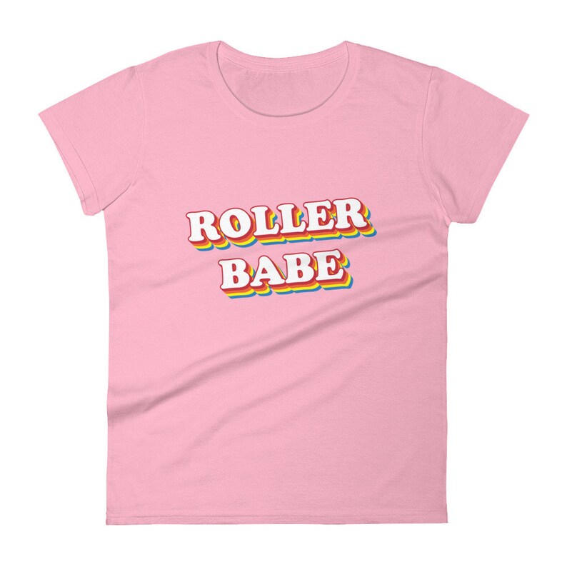 May include: A pink women's t-shirt with the text "ROLLER BABE" in a rainbow-colored, retro-style font.