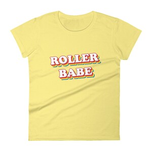 May include: A yellow women's t-shirt with the text "ROLLER BABE" in rainbow-colored letters.