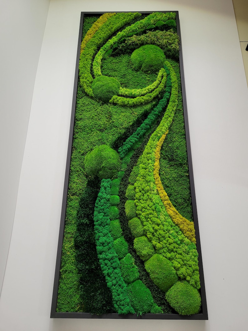 May include: A framed moss wall art piece with a swirling design in shades of green and yellow. The moss is arranged in a variety of textures and shapes, creating a unique and natural look.