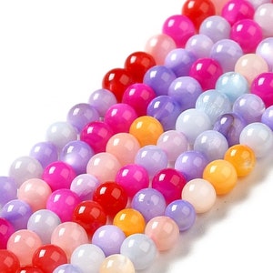 May include: A strand of colorful round beads in shades of pink, purple, yellow, and red. The beads are made of a smooth, iridescent material.