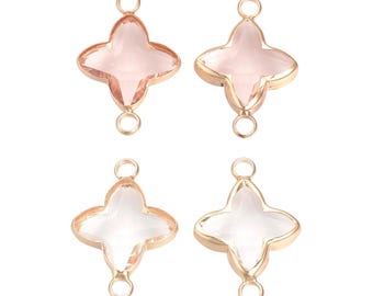 May include: Four clover-shaped charms with a light pink center and gold-colored metal trim. Each charm has a small loop at the top and bottom for attaching to other jewelry components. The charms are ideal for jewelry making.