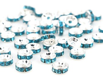 May include: A scattering of silver-toned bead caps with turquoise rhinestones. The bead caps are round and have a flat top and bottom.