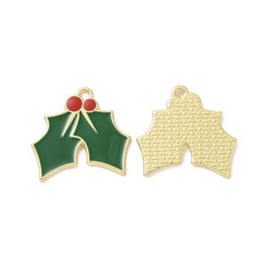 May include: Two holly leaf charms with gold-tone metal edges. One charm features green enamel leaves and two red enamel berries. The other charm shows the reverse side with a textured gold-tone metal finish and a small loop at the top for hanging.