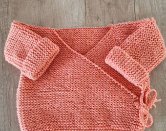 Brassière bébé naissance en laine tricotée à la main couleur mandarine . Très chaude. Se porte sur le pyjama.