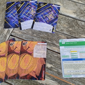 May include: Three cards with a yellow and orange leaf design and the text "FERMENTER Program: Vhe" and three blue cards with a yellow and blue maze design and the text "Ob: Superheavy Logistics Extract Export Excel Weyland Consortium".