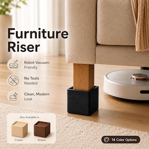 May include: A black square furniture riser supporting a wooden sofa leg, with a white robot vacuum nearby. Text reads Furniture Riser, Robot Vacuum Friendly, No Tools Needed, Clean, Modern Look, Also Available in Cream, Brown, 14 Color Options.