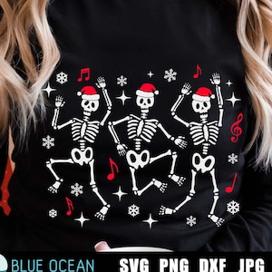 May include: A black sweatshirt with a design of three skeletons wearing Santa hats and dancing. The skeletons are surrounded by snowflakes, musical notes, and stars.