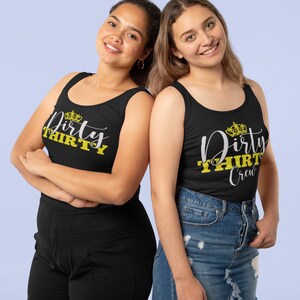 May include: Two women wearing black tank tops with the text "Dirty Thirty" and a crown graphic. One tank top says "Dirty Thirty" and the other says "Dirty Thirty Crew".