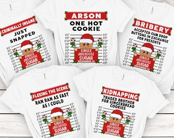 May include: Five white t-shirts with different Christmas-themed designs. Each design features a gingerbread man character with a red and white striped jailhouse background. The text on the shirts includes "Criminally Insane", "Just Snapped", "Arson One Hot Cookie", "Bribery Accepted Gum Drop Buttons in Exchange for Presents", "Fleeing the Scene Ran Ran as Fast as I Could", and "Kidnapping Traded Brother for Gingerbread Cookies".
