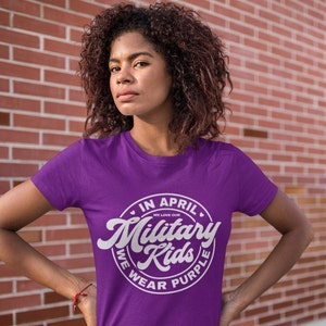 May include: Purple t-shirt with a white circle graphic that says "In April We Love Our Military Kids We Wear Purple".