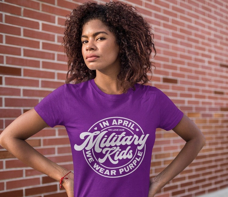 May include: Purple t-shirt with a white circle graphic that says "In April We Love Our Military Kids We Wear Purple".