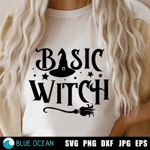 May include: A white t-shirt with a black graphic design that says "Basic Witch" with a witch's hat and a broom.