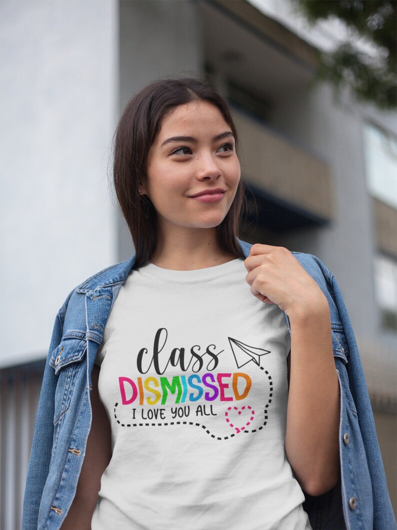 May include: White t-shirt with the text "class DISMISSED I love you all" in rainbow colours with a paper aeroplane and a heart.