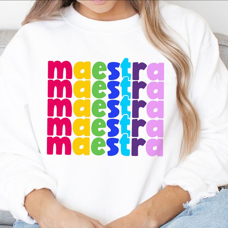 May include: White sweatshirt with the word "maestra" repeated five times in rainbow colours.
