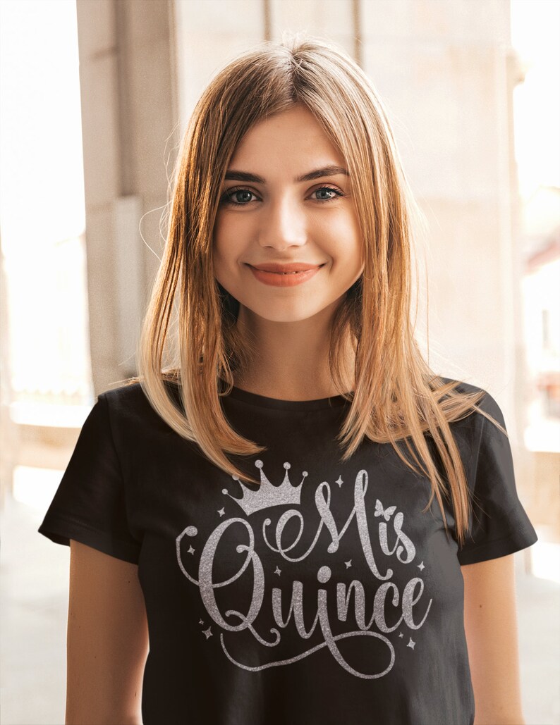 May include: A black t-shirt with a silver glitter design that says "Mis Quince" with a crown above the text.