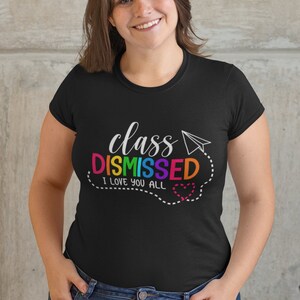 May include: Black t-shirt with the text "class DISMISSED I love you all" in rainbow colours with a paper aeroplane and a heart.