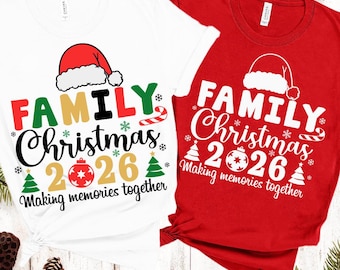 Può includere: Una t-shirt bianca e una t-shirt rossa, entrambe con una grafica raffigurante un cappello di Babbo Natale, il testo "FAMILY Christmas 2026" e la frase "Making memories together". I disegni includono piccoli alberi di Natale, fiocchi di neve e un bastoncino di zucchero.