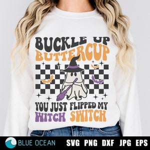 Könnte beinhalten: Weißes Sweatshirt mit einem schwarz-weißen karierten Hintergrund. Der Text "Buckle Up Buttercup" ist in orangefarbenen und gelben Buchstaben. Ein Geist mit einem lila Hut und einem Besen befindet sich in der Mitte des karierten Hintergrunds. Der Text "You Just Flipped My Witch Switch" ist in orangefarbenen und gelben Buchstaben.