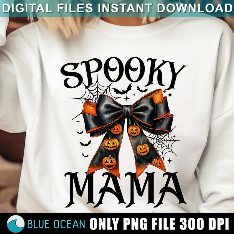 May include: A white sweatshirt with the text "Spooky Mama" in black. A black and orange bow with a spiderweb design and orange pumpkins is centered on the shirt.