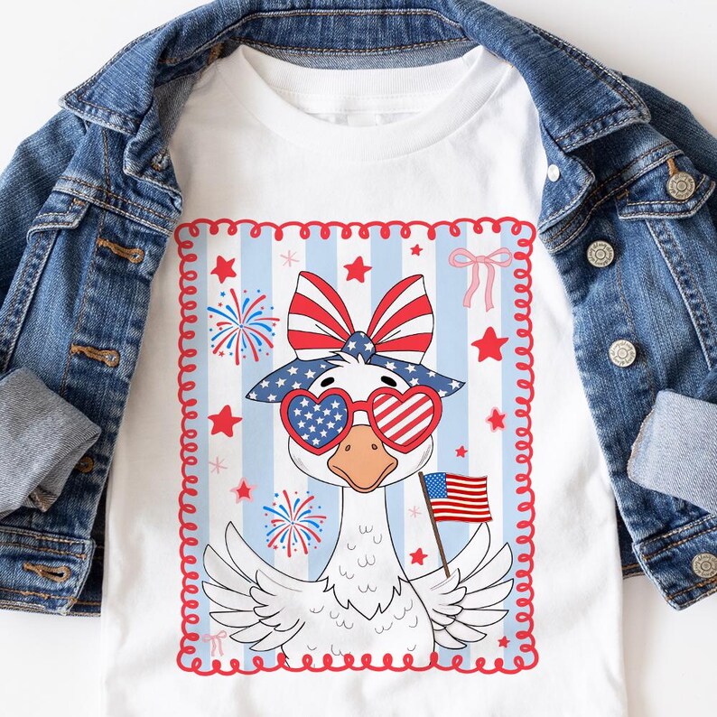 May include: A white t-shirt with a red, white, and blue goose wearing heart-shaped sunglasses and a bow. The goose is holding a small American flag. The design is surrounded by a red, white, and blue border.