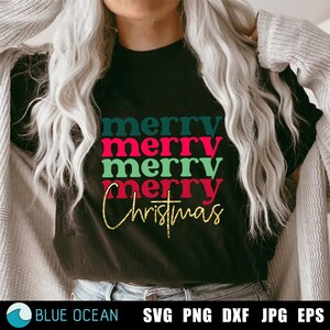 May include: A black t-shirt with the text "merry merry merry christmas" in green, red, and teal colors with gold glitter accents.