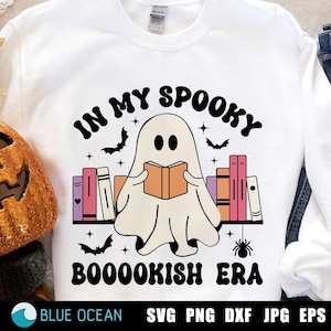 May include: A white sweatshirt with a ghost reading a book surrounded by bookshelves. The text reads "In My Spooky Booookish Era".