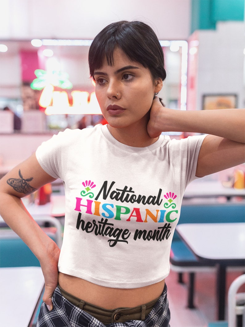 May include: White cropped t-shirt with the text "National HISPANIC heritage month" in colorful letters.