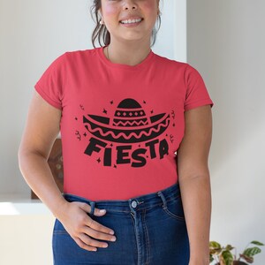May include: A red t-shirt with a black graphic of a sombrero and the word "FIESTA" on it.