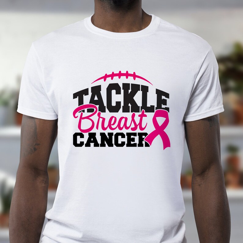 Peut inclure: T-shirt blanc avec un graphisme noir qui dit "Tackle Breast Cancer" avec un ruban rose.