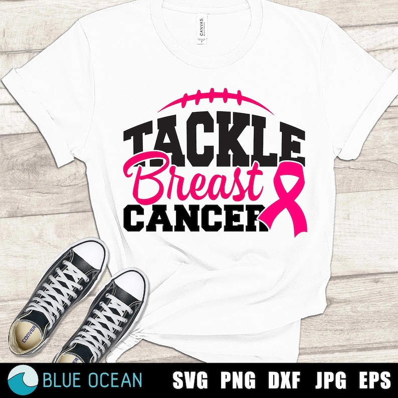 Peut inclure: T-shirt blanc avec un texte noir qui dit "Tackle Breast Cancer" avec un ruban rose et un graphique de football.