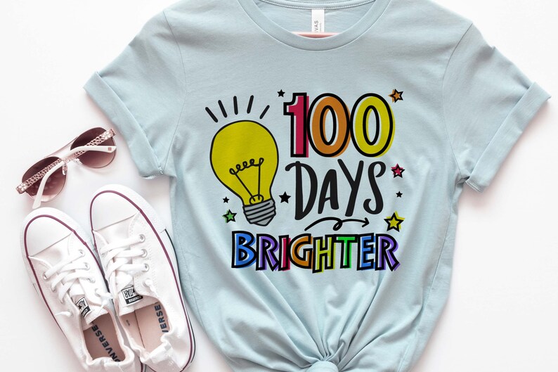 Peut inclure: Un t-shirt bleu clair avec un graphique d'ampoule color&eacute; et le texte "100 jours plus lumineux".