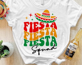 May include: White t-shirt with the text "Fiesta Fiesta Fiesta Squad" in a colorful retro font. A sombrero is above the text.