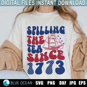 May include: A white sweatshirt with a red, white, and blue graphic design that says "Spilling the Tea Since 1773". The graphic features a ship with a red sail and a blue hull. The text is in a retro font style.
