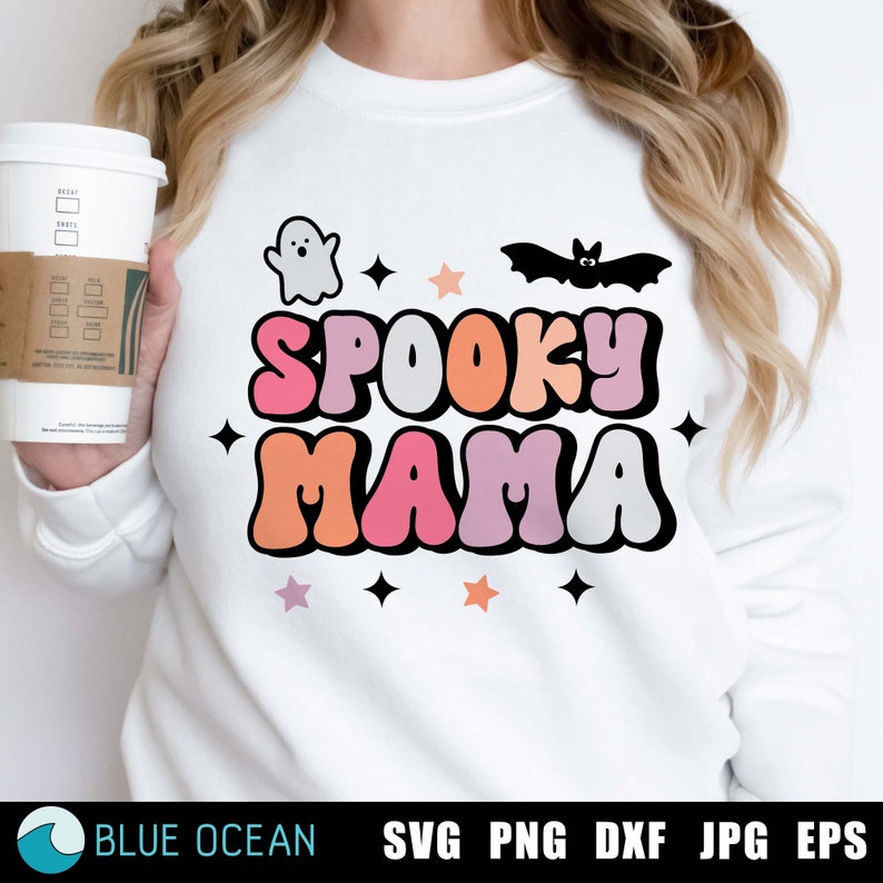 May include: A white sweatshirt with the text "Spooky Mama" in colorful retro letters. The text is surrounded by stars and images of a ghost and a bat.
