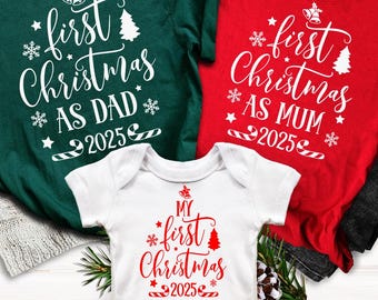 May include: A festive Christmas-themed t-shirt set. The set includes a green t-shirt with "First Christmas as Dad 2025", a red t-shirt with "First Christmas as Mum 2025", and a white onesie with "My First Christmas 2025".