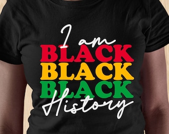 Könnte beinhalten: Schwarzes T-Shirt mit dem Text "I am Black Black Black History" in roten, gelben und grünen Buchstaben.