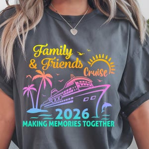 Pode incluir: Camiseta cinza escuro com um design gr&aacute;fico colorido. O design apresenta as palavras "Family & Friends Cruise 2026" com um navio de cruzeiro, palmeiras e um golfinho. O texto "MAKING MEMORIES TOGETHER" tamb&eacute;m est&aacute; inclu&iacute;do.