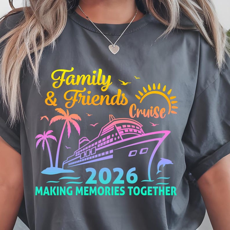 Pode incluir: Camiseta cinza escuro com um design gr&aacute;fico colorido. O design apresenta as palavras "Family & Friends Cruise 2026" com um navio de cruzeiro, palmeiras e um golfinho. O texto "MAKING MEMORIES TOGETHER" tamb&eacute;m est&aacute; inclu&iacute;do.