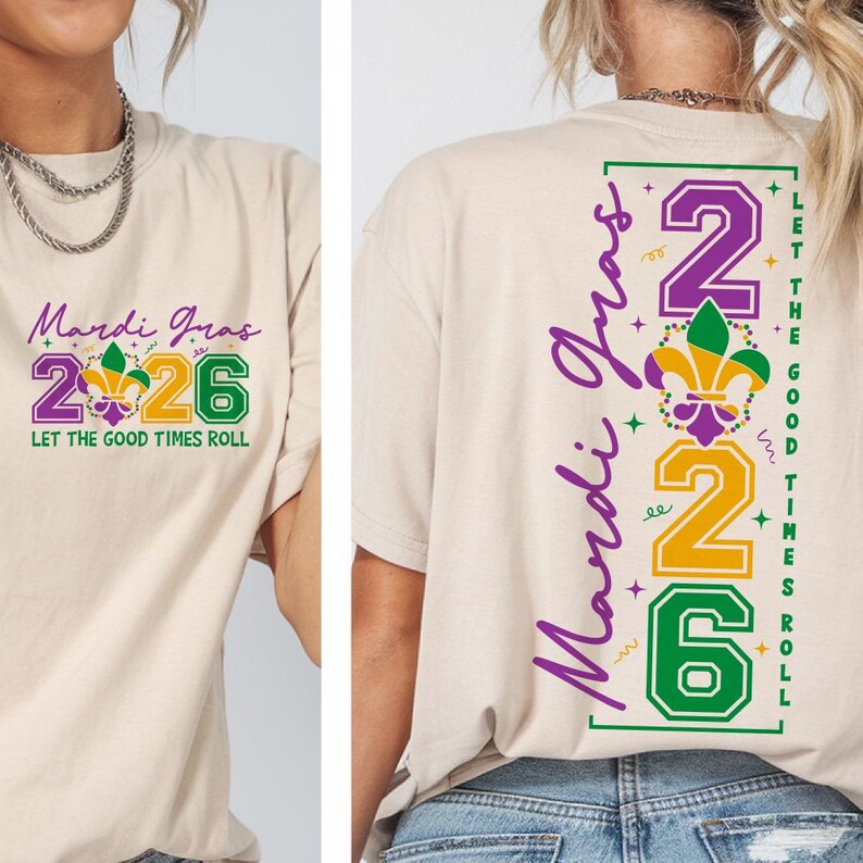 Op de afbeelding: Beige T-shirts met Mardi Gras-ontwerpen. De voorkant toont "Mardi Gras 2026" in paars, groen en goud, met "Let the Good Times Roll". De achterkant heeft "Mardi Gras" verticaal en "2026" met dezelfde tekst.