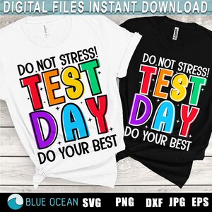May include: Two t-shirts with the text "Do Not Stress! Test Day Do Your Best" in rainbow colors. The shirts are white and black.