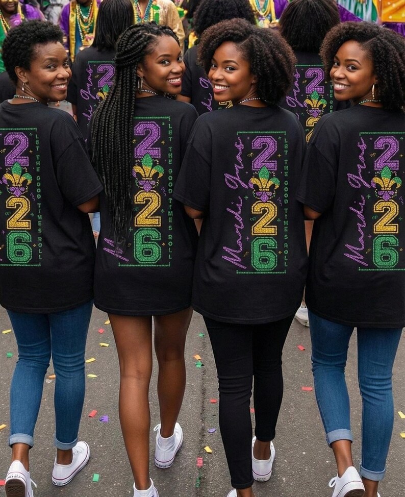Op de afbeelding: Een groep mensen draagt zwarte t-shirts met een Mardi Gras-ontwerp. Het ontwerp bevat de tekst "2026" in paars, goud en groen, samen met de woorden "Mardi Gras" en "Let the Good Times Roll."
