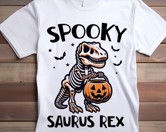 May include: White t-shirt with a black and orange graphic of a skeleton dinosaur holding a jack-o-lantern. The text "Spooky Saurus Rex" is printed below the dinosaur.