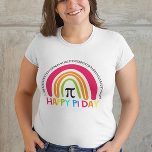 May include: White t-shirt featuring a rainbow design with the pi symbol and numbers, and the text "Happy Pi Day." The shirt is worn by a person with brown hair and blue jeans.